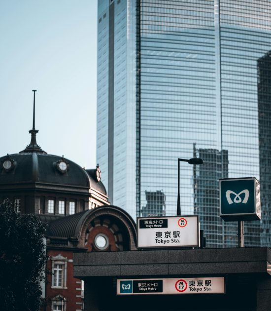View of Tokyo Station with a modern skyscraper in the background, embodying urban contrast.